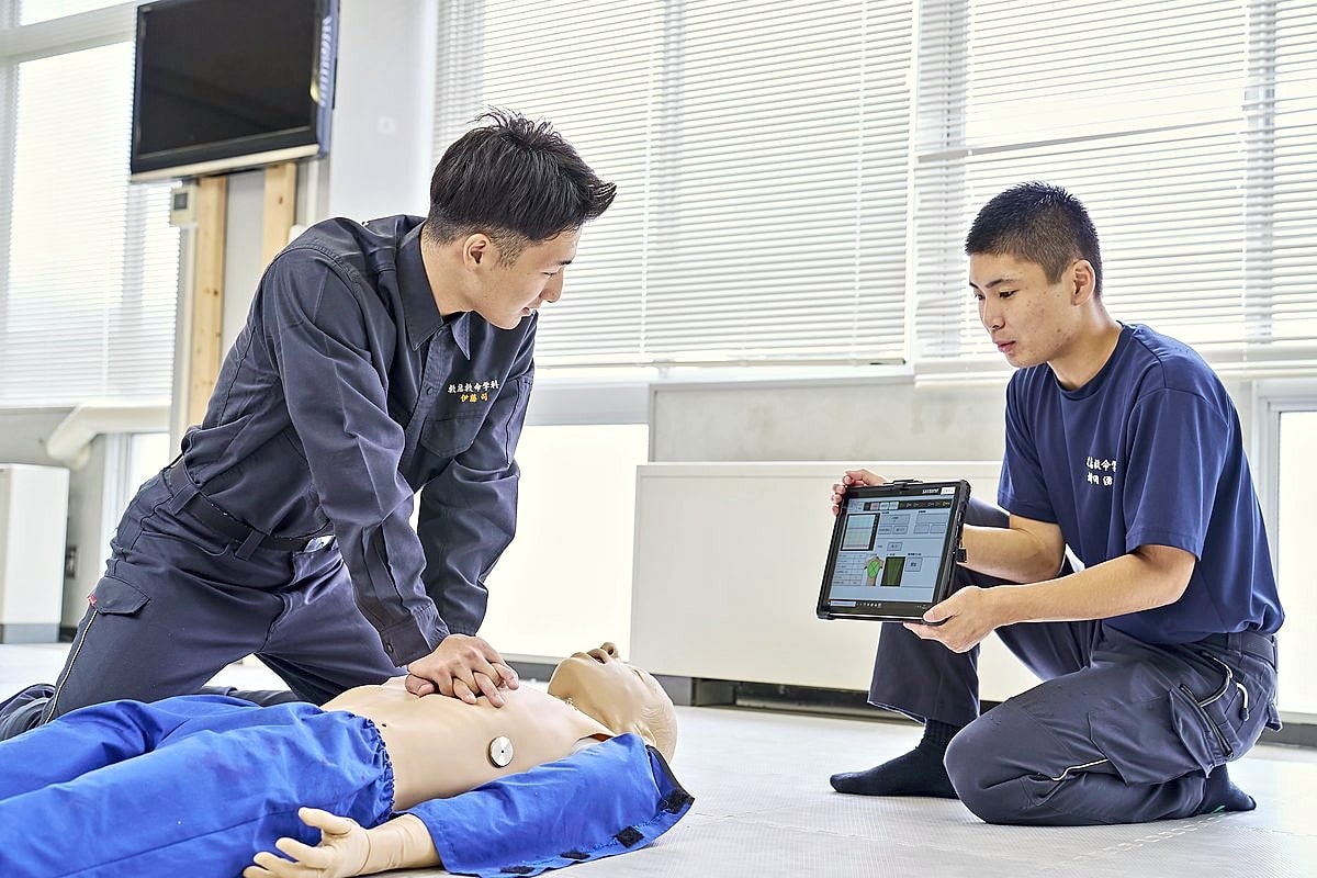 セーブマン プロで胸骨圧迫を行い、タブレットで数値を確認する学生