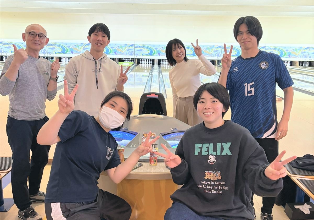 ボウリング場で記念撮影をする学生と教員